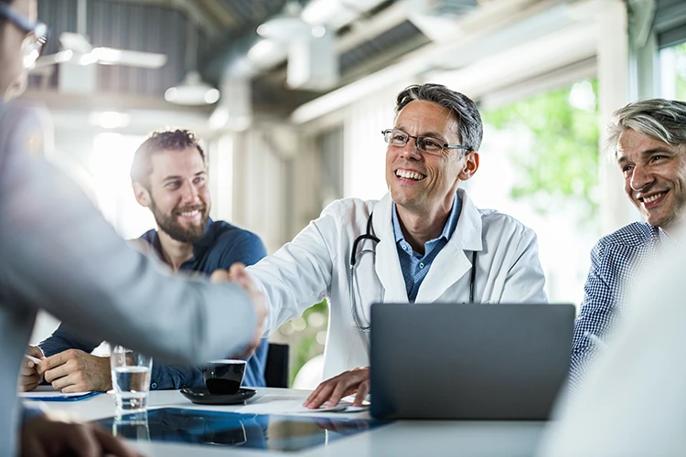 A physician meets with business leaders about a healthcare partnership