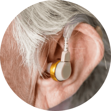 An aged woman wearing a hearing aid after getting an audiology treatment in San Antonio, TX